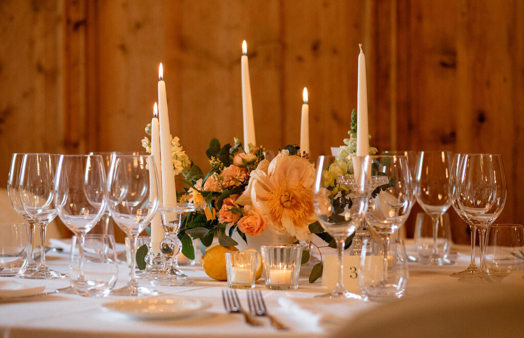 Decorazione floreale dei tavoli con peonie rose candele e agrumi