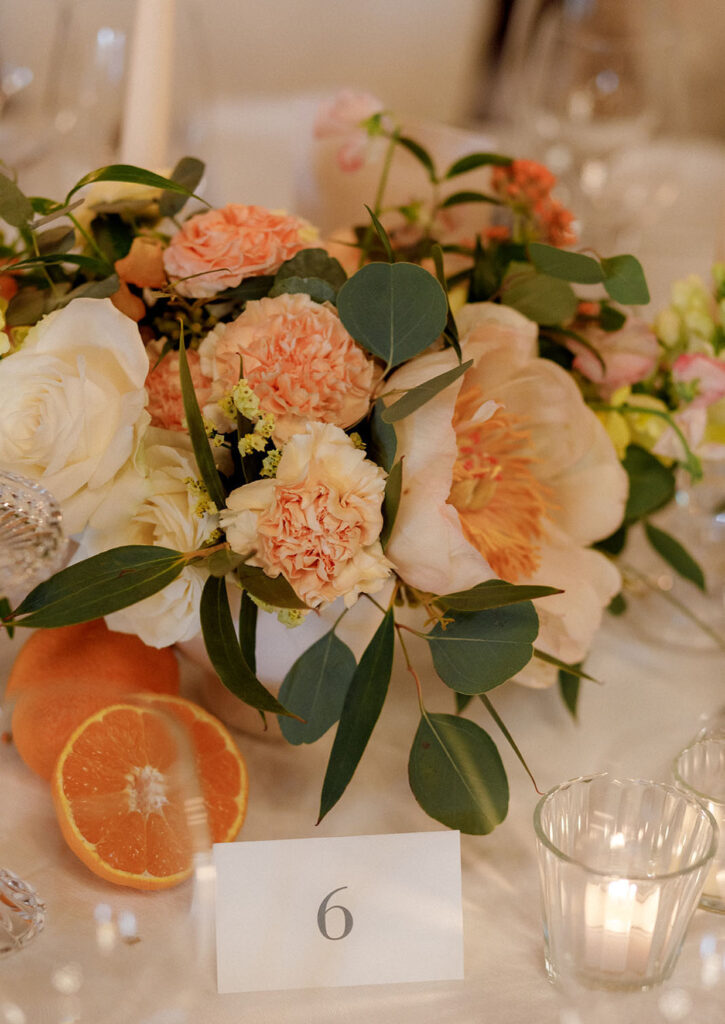 Decorazione floreale dei tavoli con peonie rose candele e agrumi