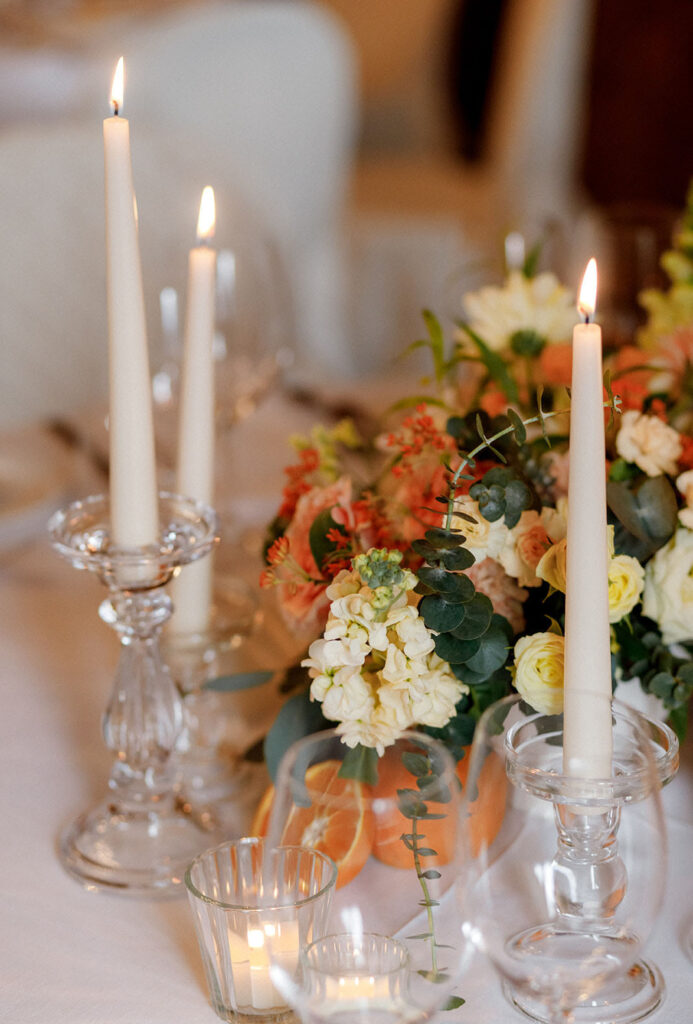 Decorazione floreale dei tavoli con peonie rose candele e agrumi